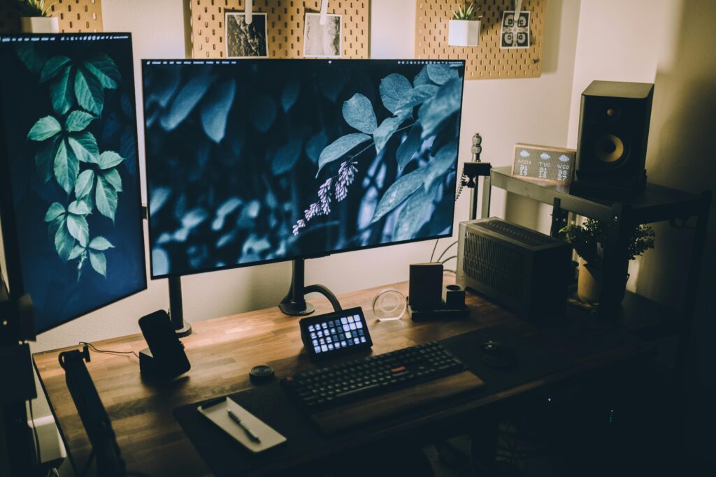 Stylish and functional home office with dual monitors, keyboard, and sound system, perfect for productivity and creativity.